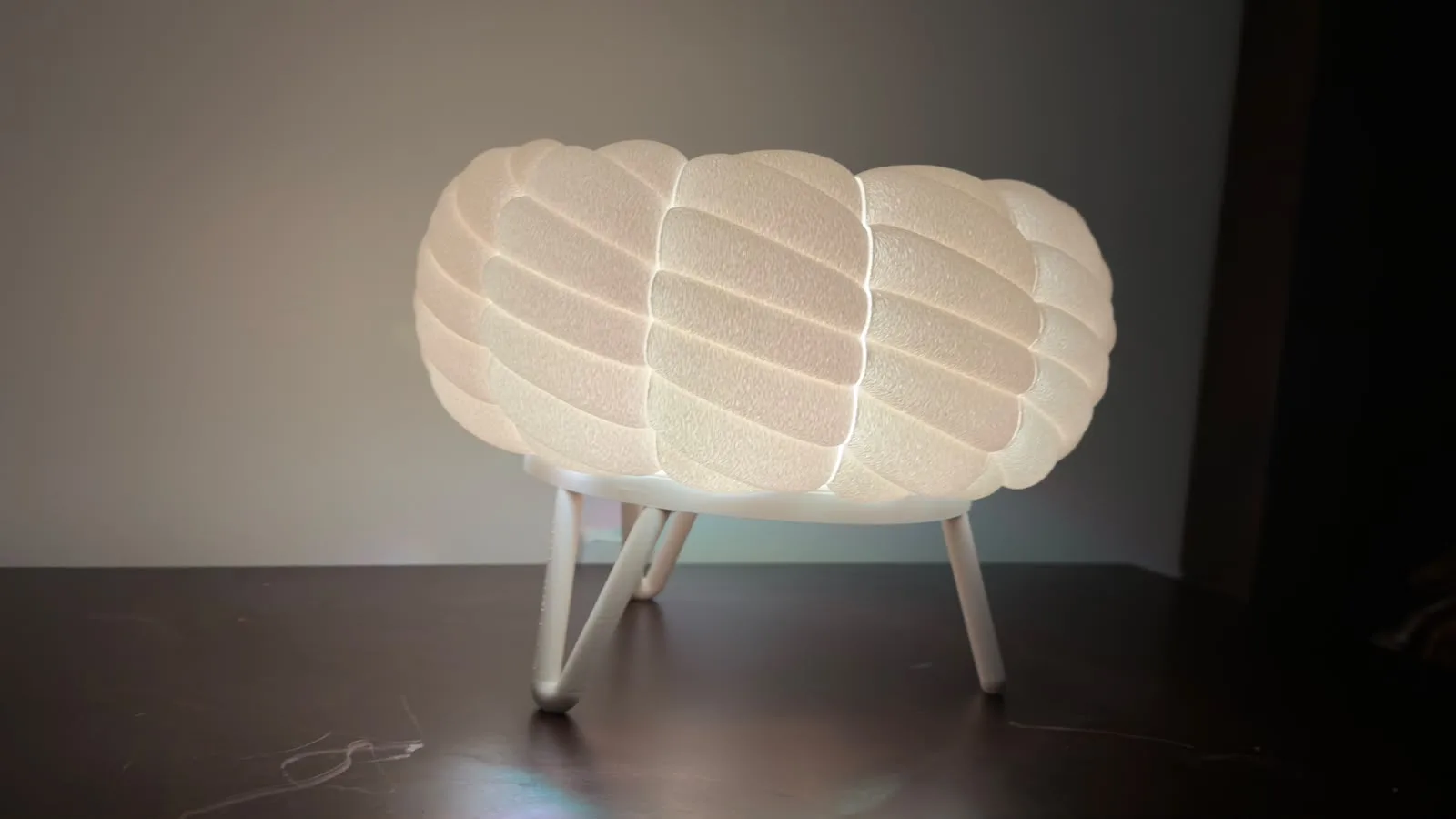 Cloud table lamp seen from the front: glowing white textured shade on white hairpin legs