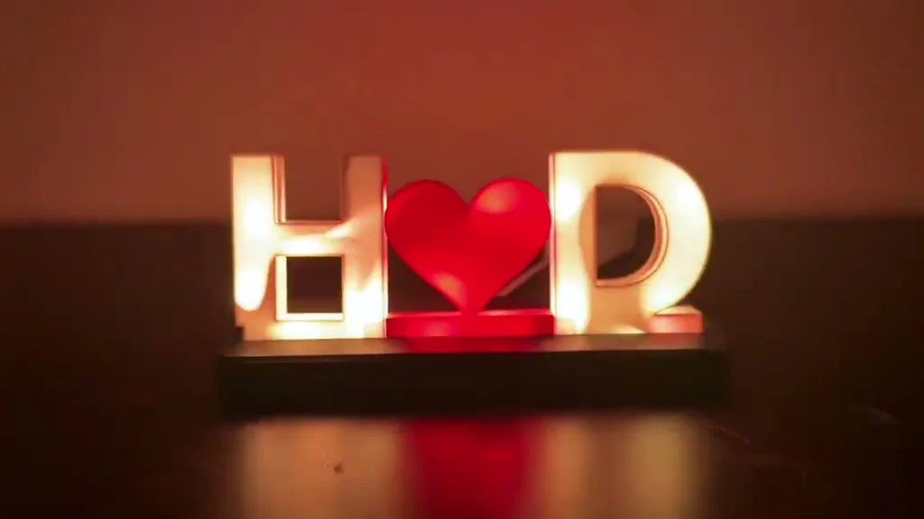Initials name lamp reading H, heart, D, glowing warm white on a dark base